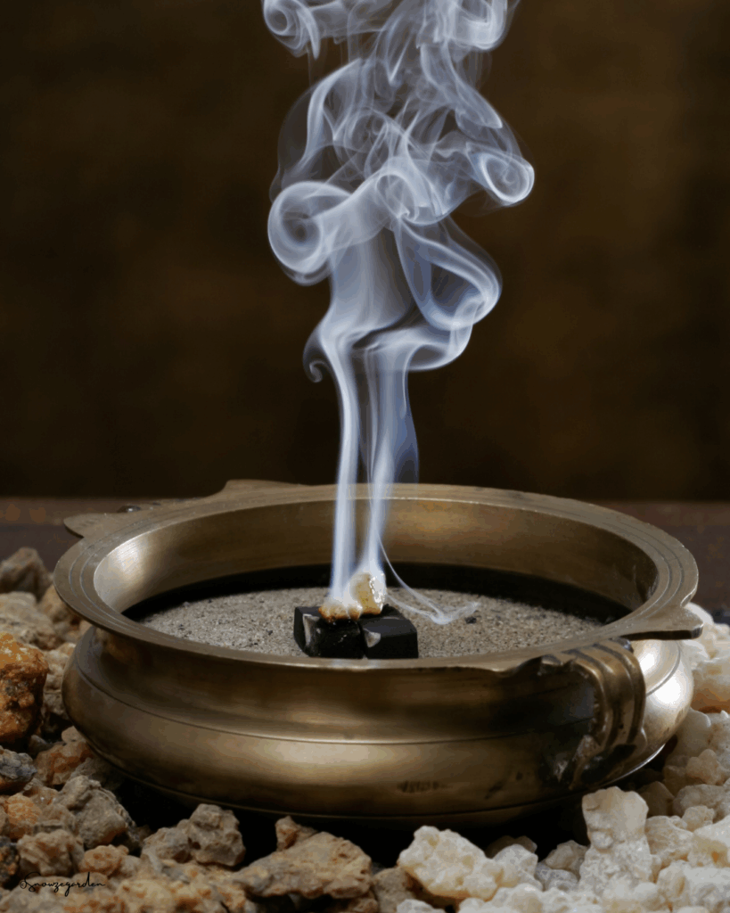フランキンセンス樹脂を炭の上で温め、香りを立ち上らせている薫香の写真。白い煙と樹脂の質感が映る、冬の特別体験を示すイメージ。
